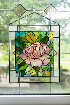 a stained glass window with a pink rose on it