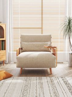 a living room scene with focus on the couch and chair in front of the window