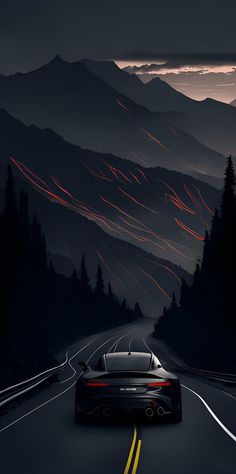 a car driving down the road at night with mountains and trees in the back ground