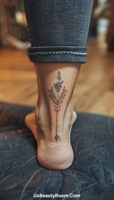 a woman's foot with a flower tattoo on the side of her leg and an arrow in the middle