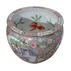 a fish bowl that is decorated with flowers and other designs on it's sides