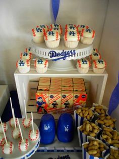 a baseball themed dessert table with cupcakes and cookies