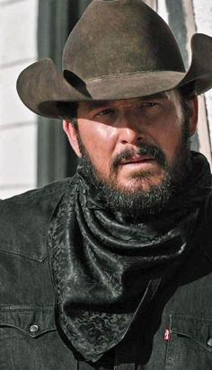 a man wearing a cowboy hat and scarf