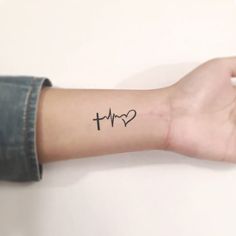 a person's arm with a heart and heartbeat tattoo on it