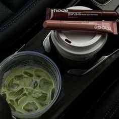 there is a drink and some candy in the cup on the car seat belt tray