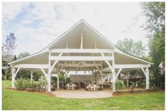 a large white building with tables and chairs under it