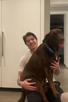 a man holding a large brown dog in his lap