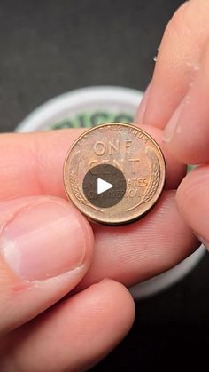 a person holding a penny in their hand with the word, one pound on it