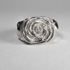 **Please note that we dispatch on Tuesdays unless special delivery express option is paid for** Sterling silver Camellia ring. Original design carved in wax then lost wax cast into solid sterling silver.  Piece weighs approximately 17g.  Shown in a size N, and adjustable to ring sizes I-S.  A significant size adjustment may alter the appearance slightly.  First class post included, with a supplement for special delivery. Carved Silver Ring, Carved Sterling Silver Rings For Anniversary, Anniversary Sterling Silver Carved Rings, Anniversary Carved Sterling Silver Ring, Unique Hand Cast Signet Ring For Anniversary, Silver Carved Sterling Silver Signet Ring, Sterling Silver Carved Promise Ring, Silver Engraved Flower Ring In Sterling Silver, Hand Cast Sterling Silver Engraved Ring For Wedding