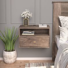 a bedroom with a bed, nightstand and potted plant