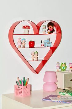 there is a heart shaped shelf with toys on it