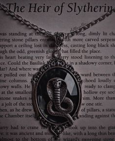 a necklace with an image of a snake in the center on top of a book