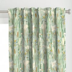 the curtains are hanging on the window sill in front of the window with white flowers and green leaves