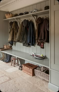 a coat rack filled with coats and shoes next to a wall mounted shoe rack in a hallway