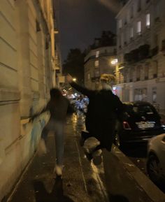 two people walking down the street at night