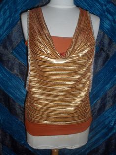 Unusual and glitzy!  Gold pleated draped neck blouson over orange stretch tank top with straps.  Rhinestone braid trim on armholes.  Back is slashed (see photo 2) and tied at neck.  There is a band of the stretch material at the hem which can be pulled down on the hips or worn on the waist for a more bloused effect.  Deep armholes to reveal the tank top. Made in France. Washable. No size or maker's labels. 92% Polyester 8% Elastane Measured flat  in inches Bust (stretched)  17ins (Tank top part) Gold And Orange, Pleated Drapes, Stretch Band, Rhinestone Trim, Stretch Bands, Trim Top, Clothing Items, Bathing Beauties, One Piece