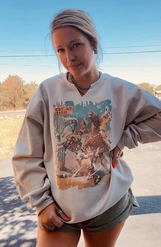 This classic crewneck is perfect for when you want to combine style and comfort. The Cactus Motel Cowboy Comic Sweatshirt features a V-cut neckline, soft, fleece lining, and a western-inspired graphic. Perfect for cooler fall weather. Cowboy Comic, Desert Adventure, Western Sweatshirts, Western Vibes, Denim Romper, Comfy Sweatshirt, V Cut, V Cuts, Jacket Buttons