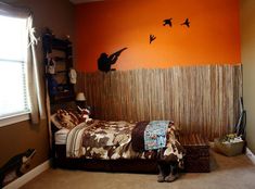 a bed room with a neatly made bed and birds painted on the wall