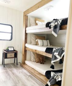 bunk beds in a small room with white walls and wood flooring on the side