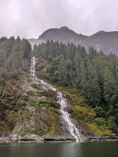 a large waterfall in the middle of a forest