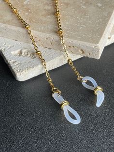 This beautiful high quality satellite chain is heavily plated in non tarnish 24K gold. The flattened links are soldered closed for strength and durability. This excellent quality gold chain is delicate yet very sturdy and will hold your expensive glasses safe and secure when not in use. **Measures 26 inches. **High quality 24K gold chain is finished off with clear eyeglass grips with gold plated slide adjusters for a secure hold on glasses arms. **Your package will arrive beautifully packaged an Metal Glasses Chains As Gift, Modern Metal Glasses Chains With Adjustable Chain, Metal Glasses Chain With Adjustable Chain As Gift, Gold Minimalist Glasses Chain With Adjustable Feature, Gold Minimalist Glasses Chains With Adjustable Chain, Minimalist Gold Adjustable Glasses Chain, Modern Adjustable Gold Glasses Chains, Silver Delicate Metal Glasses Chain, Gold Chain Glasses Chains Made Of Glass For Gift