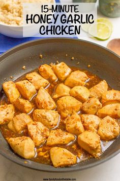 a pan filled with chicken and sauce on top of a table next to a bowl of rice