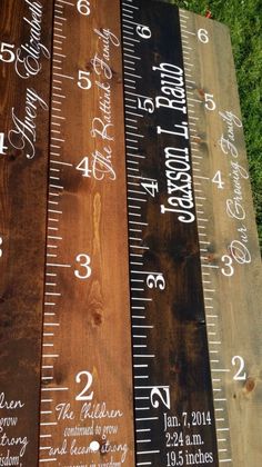 three wooden rulers with numbers on them sitting next to each other in front of some grass