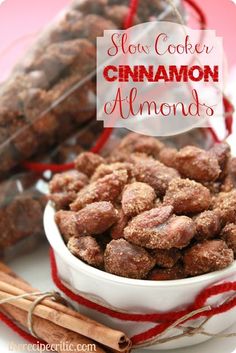 slow cooker cinnamon almonds in a white bowl with cinnamon sticks next to it