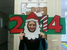 a woman holding up a sign with santa clause on it in front of her face