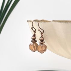 Beautiful peach cathedral bead earrings. Small, dainty, petite earrings. Perfect for those who prefer small dangle earrings. Handmade with an 8mm Czech glass cathedral bead. This bead is a beautiful light peach or champagne color with a copper finish on the top and bottom of the bead. Paired with copper wires and accent beads, this creates a pair that would be pretty for a rustic wedding. Each pair of earrings comes with a soft, flexible, clear back to keep your earrings securely in place. SIZE: Glass Cathedral, Small Dangle Earrings, Peach Earrings, Petite Earrings, Minimalist Gifts, Light Peach, Earrings Minimalist, Copper Finish, Champagne Color