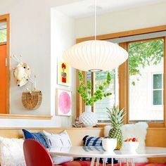 a living room with red chairs and a white table