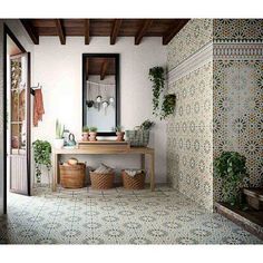 a bathroom with tiled floors and walls has potted plants on the counter next to it