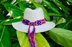 "These braided hat bands will liven up your Spring and Summer wardrobe. They are carefully woven together by hand using bright, festive colors of string. Each pattern is unique! Handmade in Chiapas, Mexico Details | Detalles: 20\" band length, 36\" total length, 2\" wide." Bohemian Multicolor Toquilla Straw Sun Hat, White Toquilla Straw Panama Hat For Festivals, White Handmade Adjustable Panama Hat, Woven Panama Hat With Curved Brim For Festivals, Handwoven Short Brim Panama Hat For Festival, Curved Brim Woven Panama Hat For Festivals, White Woven Hat Bands For Beach, Multicolor Woven Brimmed Panama Hat, White Toquilla Straw Hat For Festival