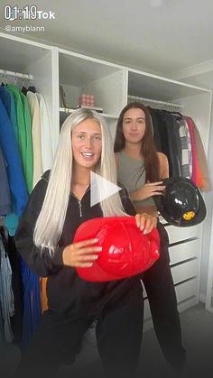 two women standing in front of a closet holding a red ball and black helmet while another woman looks at the camera