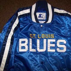 New W Tags Nhl St. Louis Blues Starter Jacket. High Quality Polyester Satin Jacket With A Snap Up Front And Ribbed Knitted Cuffs, Collar And Waist Band. The Jacket Has A Polyester Outer Shell And The Inside Lining Is Soft Polyester. The St. Louis Blues Lettering Blues Logo Meticulously Sewn On. New Starter 2019. Color: Blue With White Sewn On Lettering And Yellow & White Trim. Satisfaction Guaranteed Or Return. Measurements: L: 25" Xl 26" 2x: 28" Across Chest. Blue Varsity Jacket For Sports Events, Blue Casual Varsity Jacket For Sports Events, Blue Long Sleeve Varsity Jacket For Sports Events, Navy Collegiate Outerwear For Sports Events, Blue Winter Track Jacket For College, Blue Spring Outerwear For College, Blue Collegiate Varsity Jacket For Sports, Collegiate Blue Varsity Jacket For Sports, Blue Collegiate Varsity Jacket For Sports Events