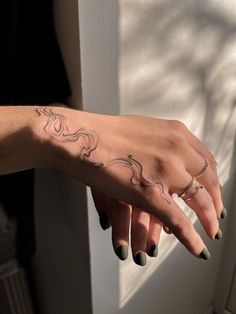 a woman's hand with a small tattoo on her left arm and the other half of her finger