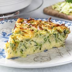 a slice of quiche on a blue and white plate