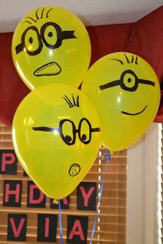 three yellow balloons with faces drawn on them