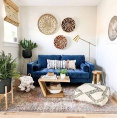 a living room with blue couches and rugs on the floor in front of two plants