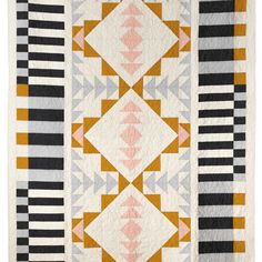 an orange, black and white quilt with geometric designs