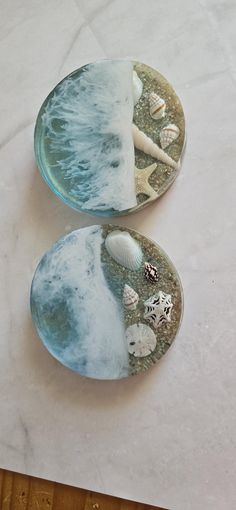 two plates with shells on them sitting on a table