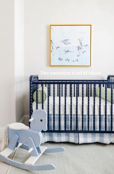 a baby's room with a rocking horse in the foreground and a painting on the wall