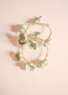 Introducing the Poppy Hoop in a new color- Honeydew! These earrings crafted with the utmost care right here in our jewelry studio. Delicate gold-plated brass ear hoops are adorned with intricate clay flowers hand sculpted and wrapped around the hoop, creating an elegant juxtaposition of textures. We are obsessed with this eye-catching green color! They are so perfect for Spring and Summer! These classic Rose & Clay hoops offer a lightweight, yet statement-making look that won't go unnoticed. Thi Gold Polymer Clay Jewelry With 3d Flowers, Gold Jewelry With 3d Flowers In Polymer Clay, Gold Flower Jewelry In Polymer Clay, Gold Polymer Clay Flower Jewelry, Gold Flower Polymer Clay Jewelry, Gold Flower-shaped Polymer Clay Jewelry, Spring Gold Jewelry With Handmade Flowers, Heavy Earrings, Jewelry Studio