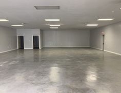 an empty room with several doors and lights on the ceiling is seen in this image