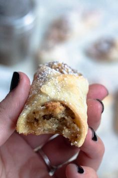 a person holding a pastry in their hand with the words christmas walnut cookies on it