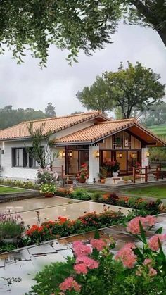 the house is surrounded by flowers and trees