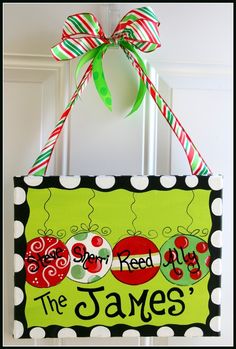 a hand painted sign hanging on the front door of a house that is decorated with green and red ladybugs