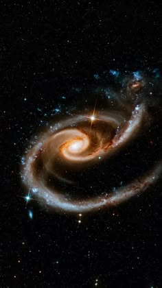 two spiral galaxys in the sky with stars around them, and one is black