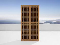 a tall wooden cabinet sitting on top of a white floor next to a blue sky