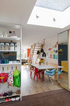 a room that has some shelves and chairs in it with various items on the floor